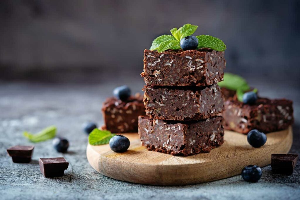 Tagliere con sopra delle fette di torta al cioccolato con avena