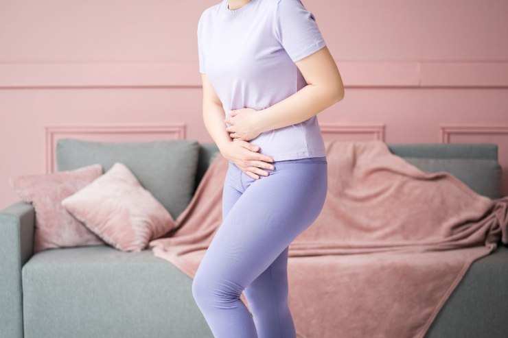 ragazza in piedi con dolore alla pancia