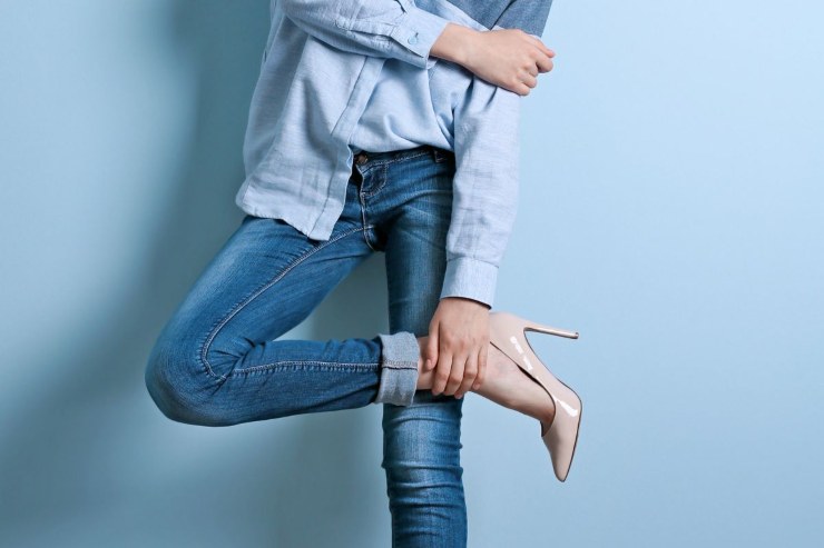 ragazza che indossa camicia azzurra, jeans e décolleté