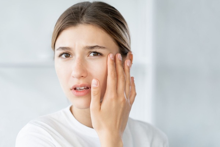 ragazza che si tocca il viso davanti allo specchio