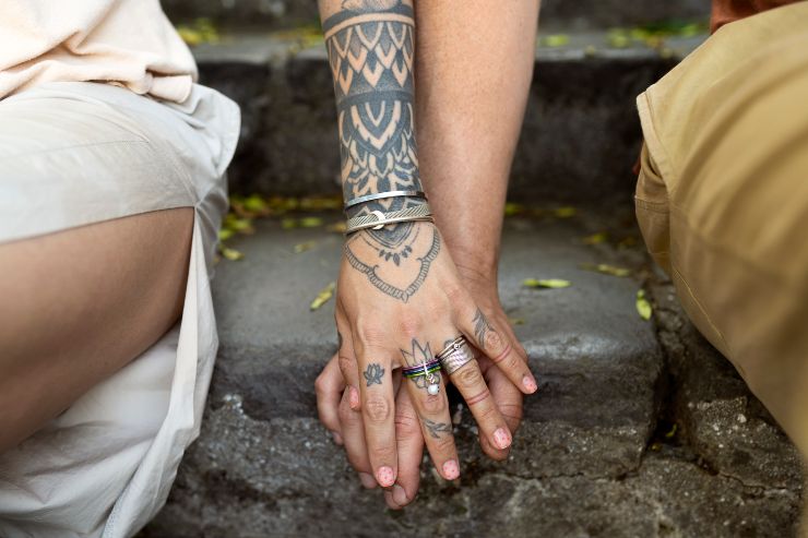 coppia seduta con tatuaggi sulle braccia