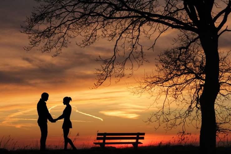 coppia fidanzati al tramonto che si tengono per mano