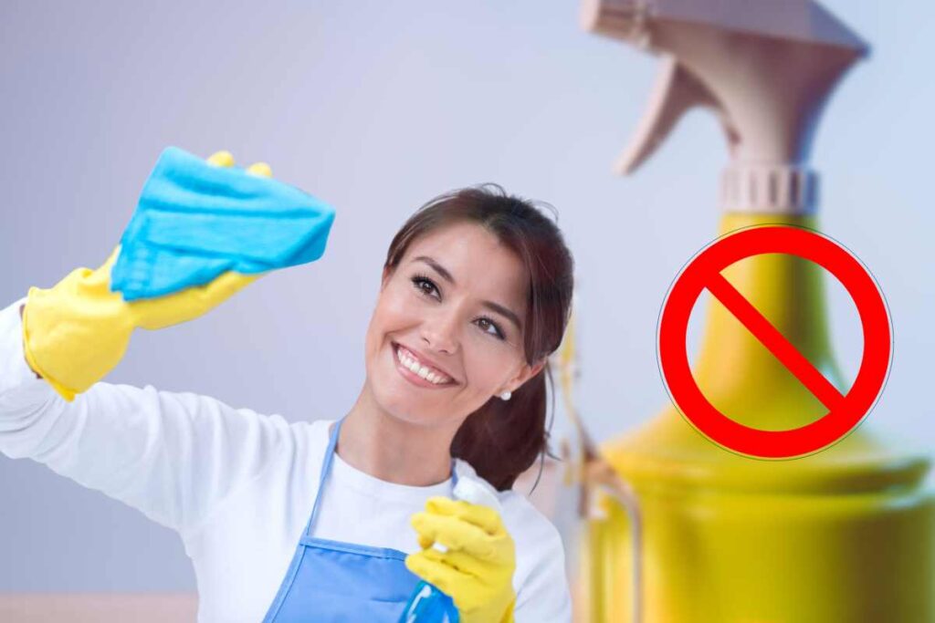 donna che fa pulizie segno divieto su prodotto pulizia