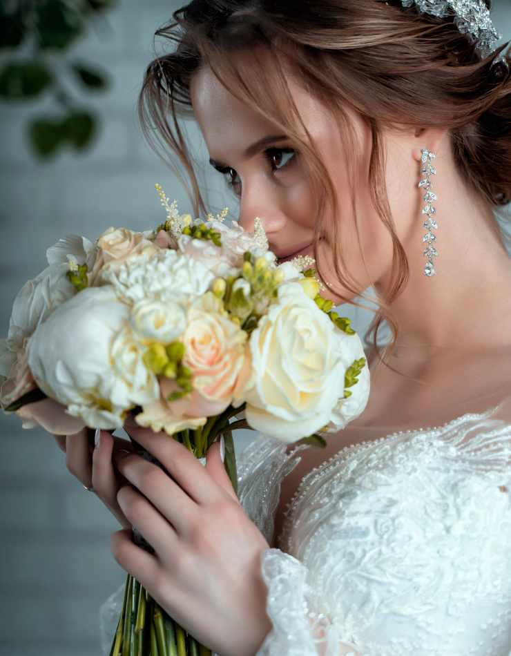 sposa con bouquet, orecchini lunghi e coroncina