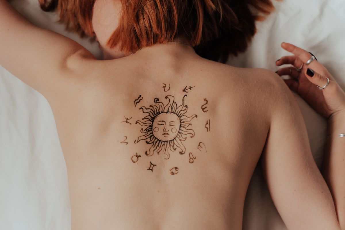 ragazza con segni zodiacali tattoo