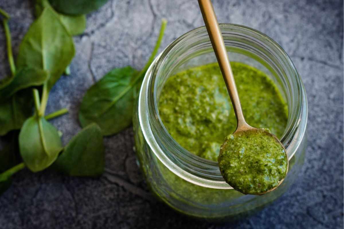 pesto di basilico in un contenitore con cucchiaino