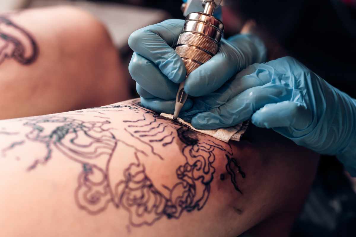 mano che disegna tatuaggio con macchinetta