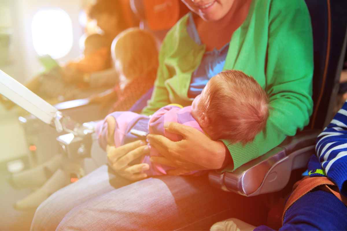 Donna con neonato in braccio nell'aereo