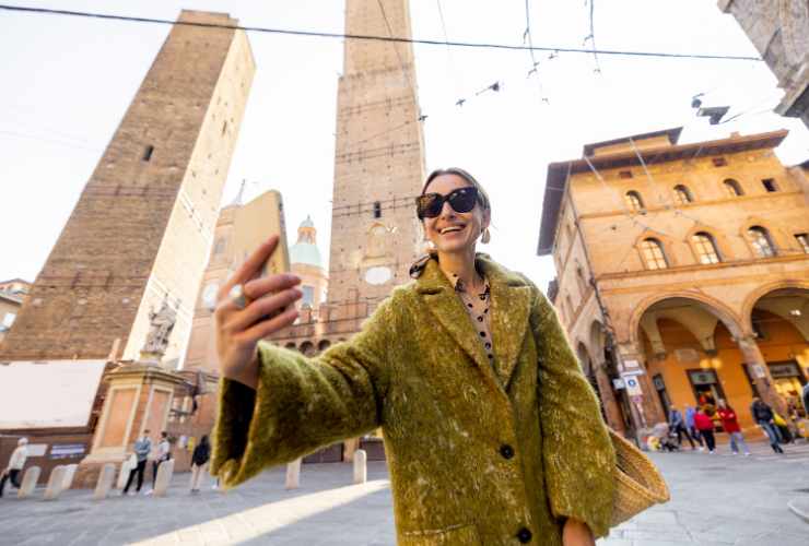 turista donna che scatta selfie a Bologna