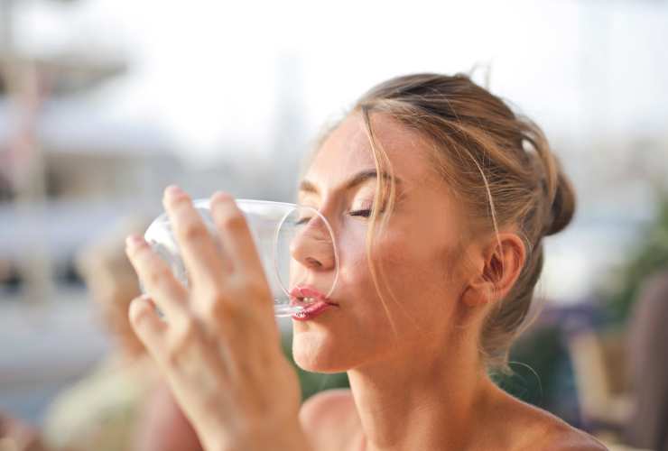 donna che beve un bicchiere d'acqua