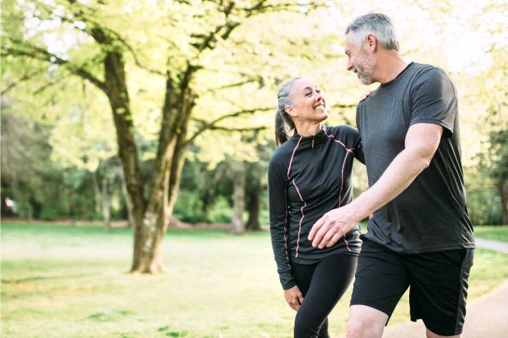 coppia over 60 che fa esercizio fisico al parco