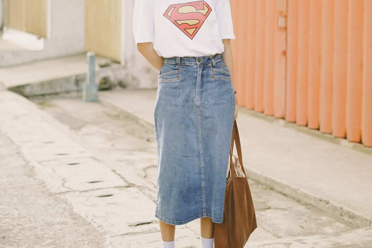 ragazza in piedi con look gonna di jeans lunga