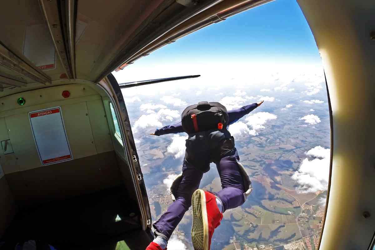 Ragazzo che si lancia con il paracadute dall'aereo