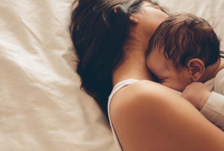 neonato che dorme attaccato alla mamma