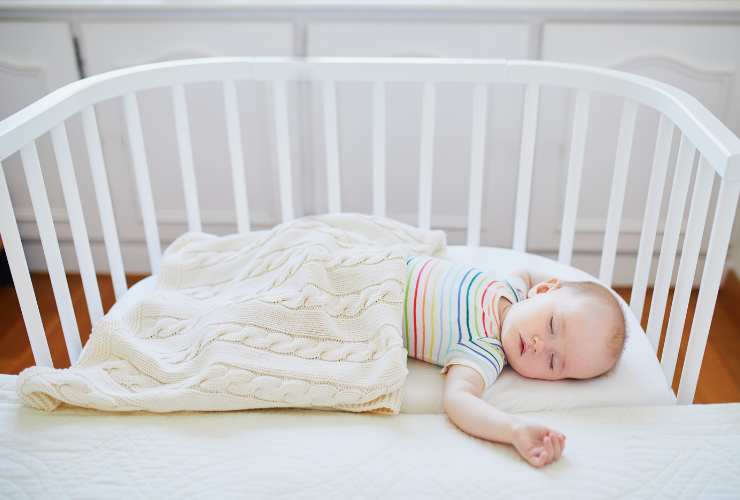 neonato che dorme in una culla co-sleeping