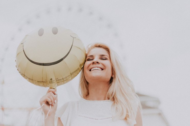 ragazza felice con palloncino a forma di smile