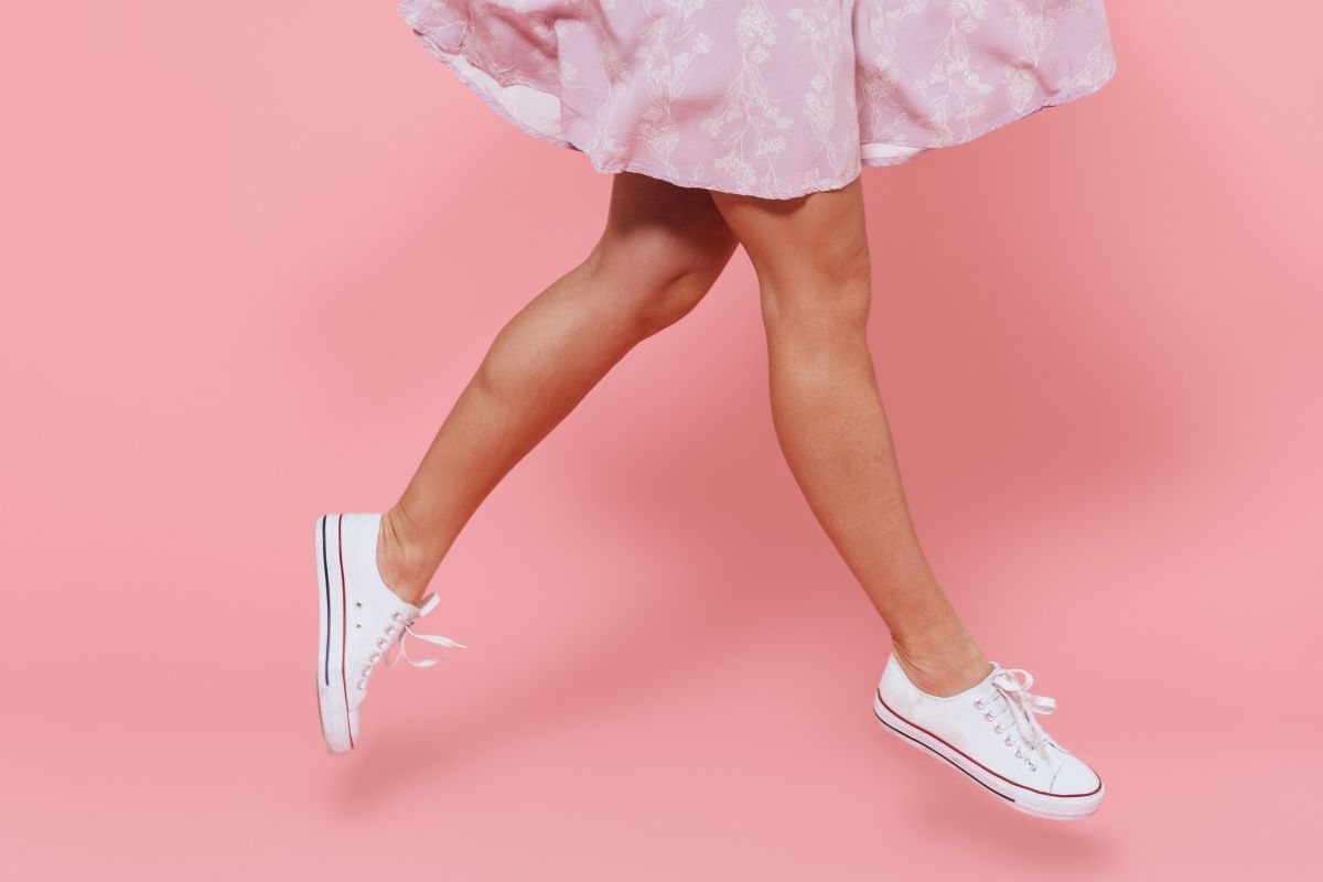 ragazza con abito e scarpe da ginnastica