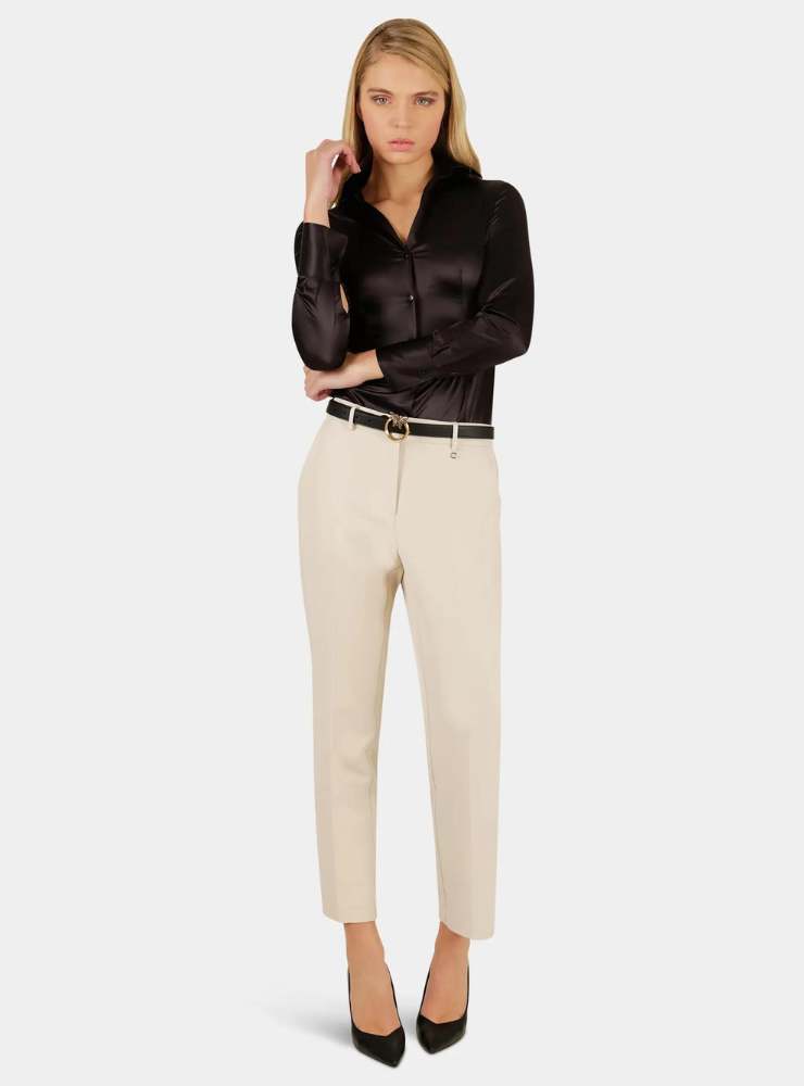 modella camicia nera pantaloni beige