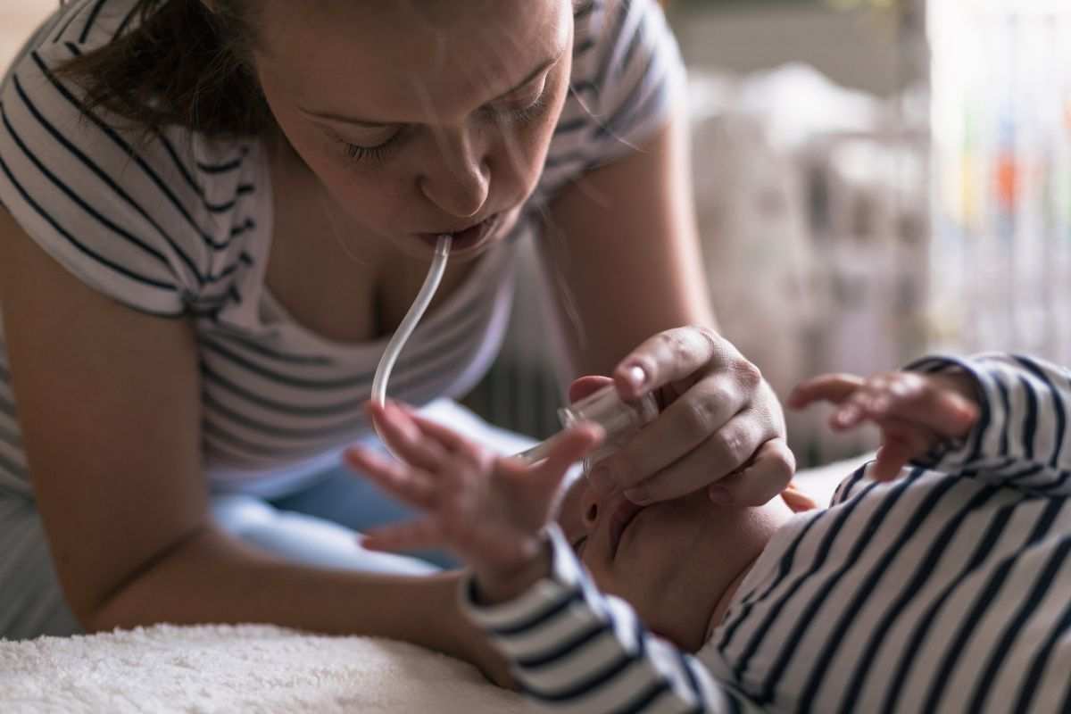 mamma che pulisce nasino neonato