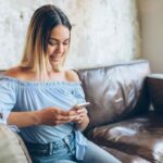 ragazza sul divano usa smartphone