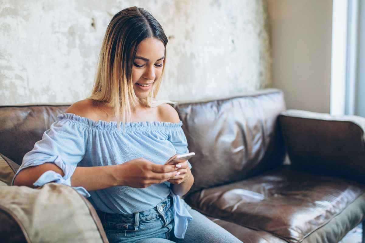 ragazza sul divano usa smartphone