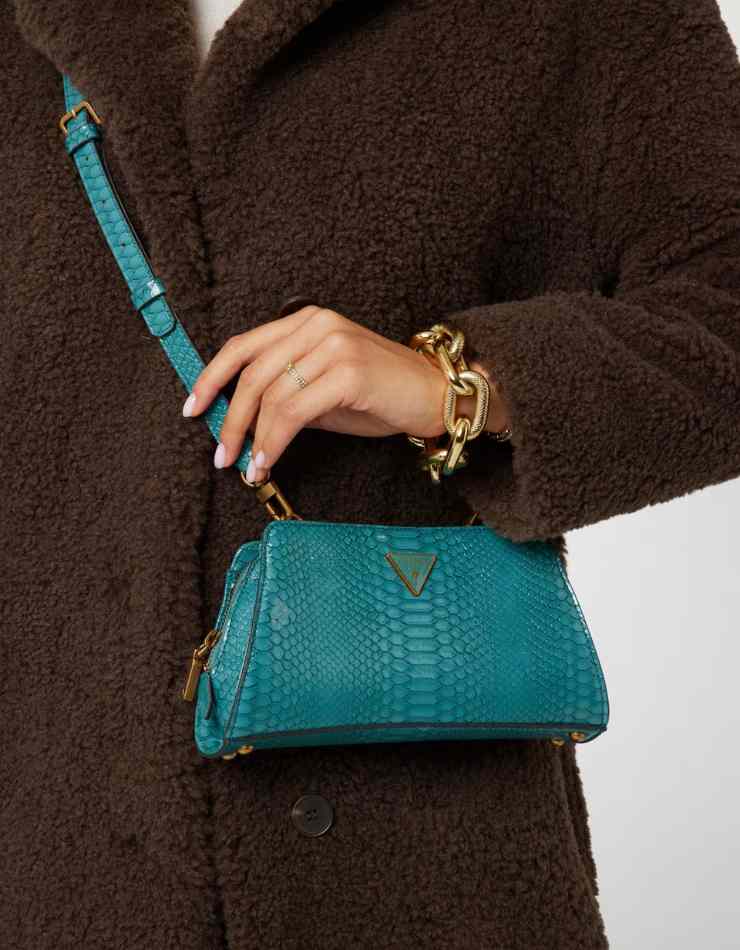 mano donna con borsa a tracolla blu