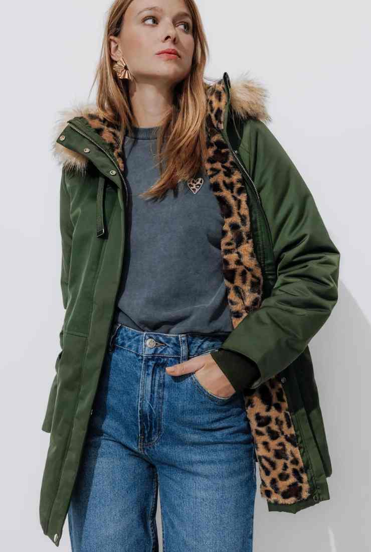 modella con parka verde maglia grigia e jeans