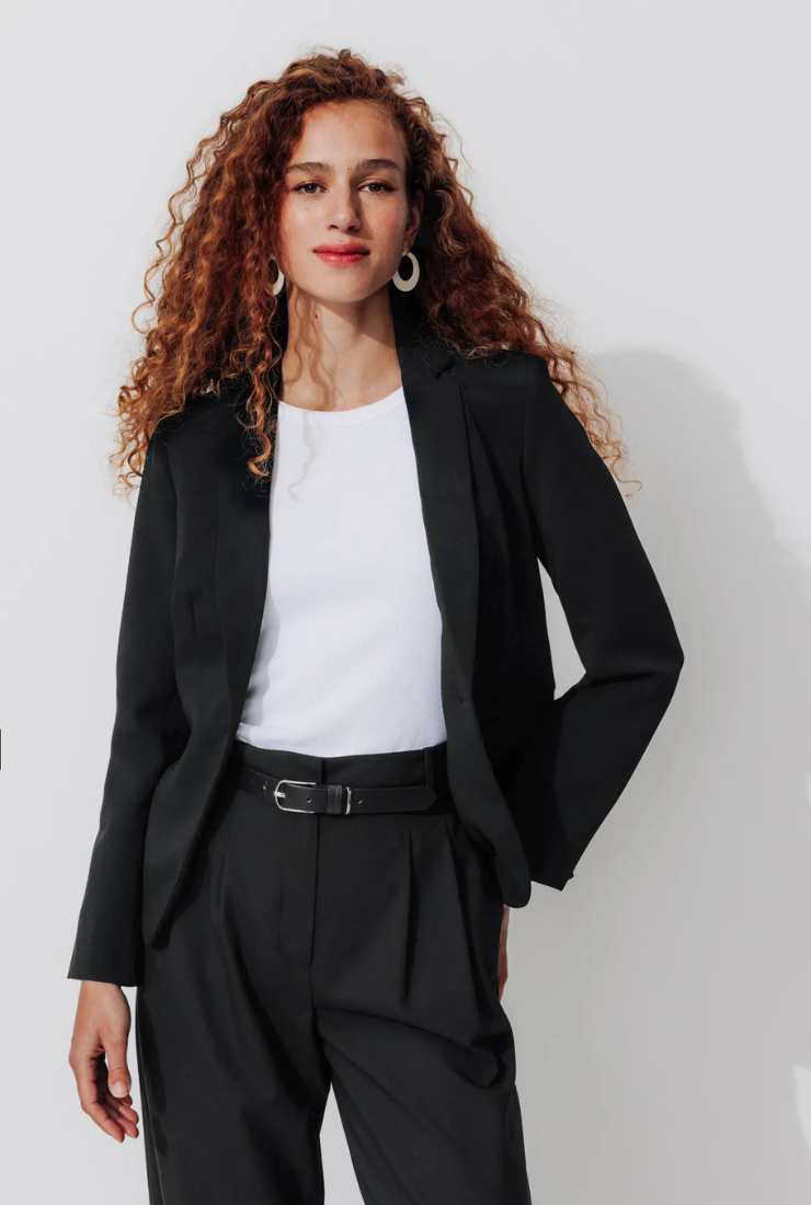 modella blazer nero, maglia bianca e pantaloni neri con pences