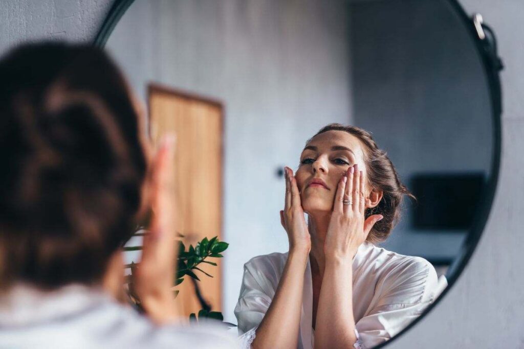 ragazza di fronte lo specchio che fa la skincare