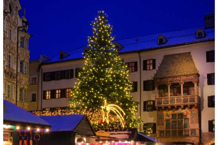 piazza con grande albero di Natale e bancarelle natalizie