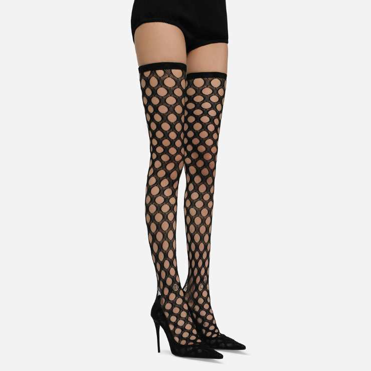 gambe modella con stivali cuissardes in rete stretch nera e tacchi alti