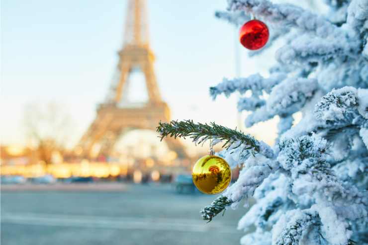 albero di Natale con neve e palline e Torre Eiffel sullo sfondo