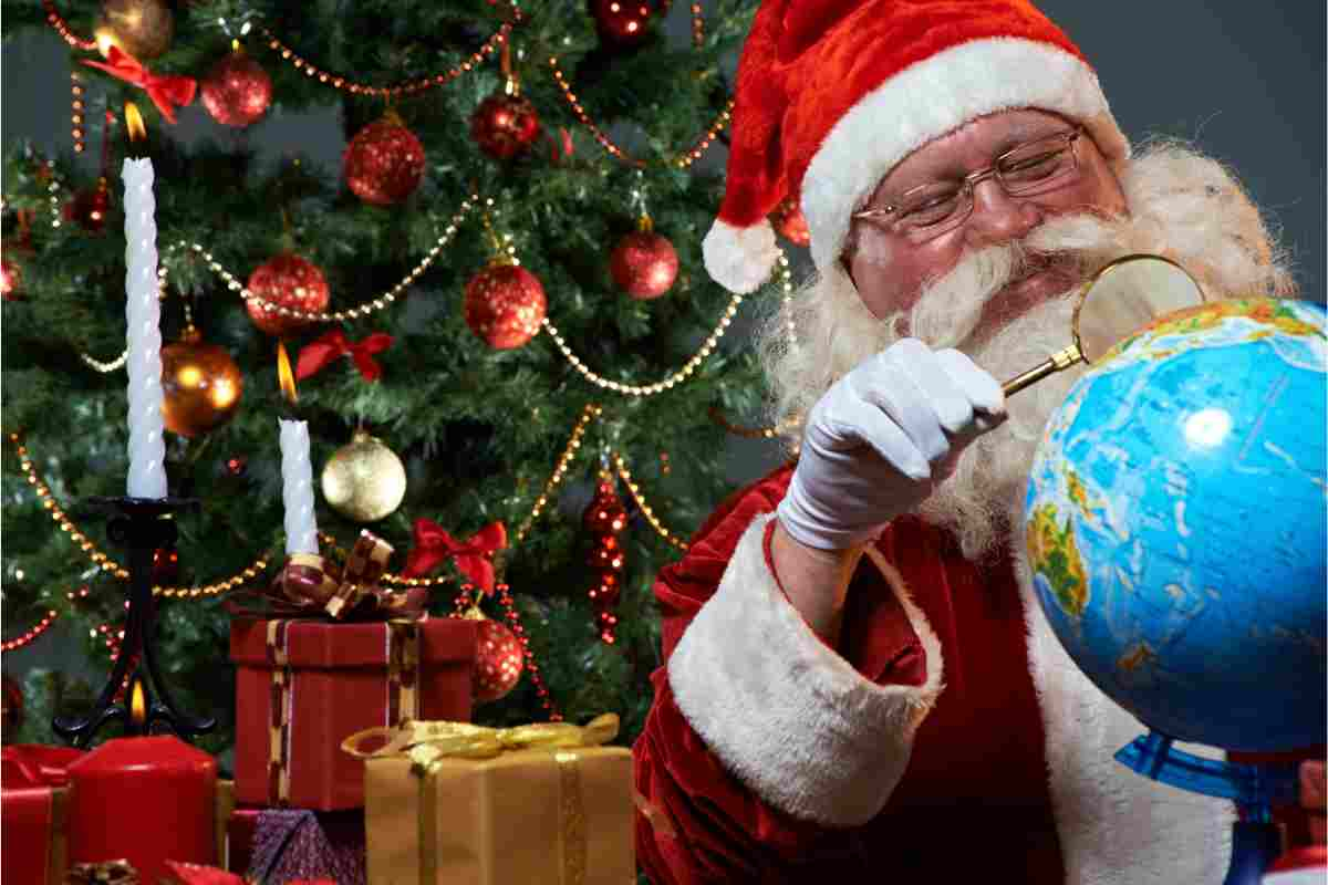 Babbo Natale con mappamondo e lente d'ingrandimento