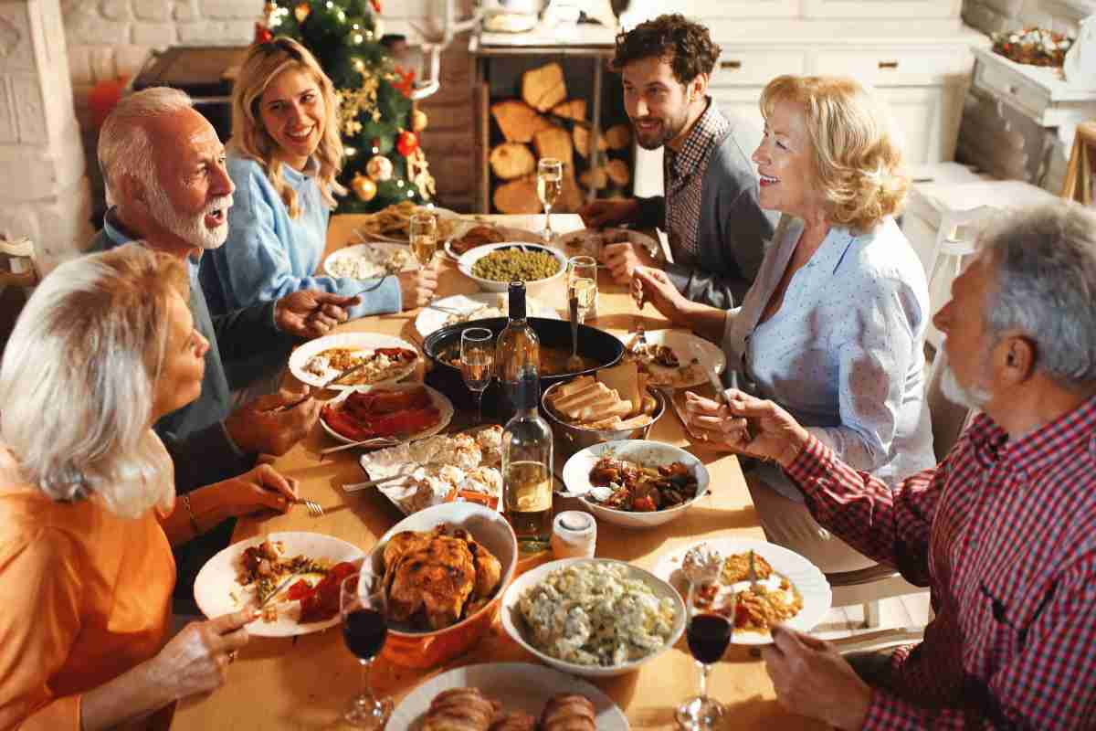 coppia con suoceri riunita al tavolo per il pranzo di Natale