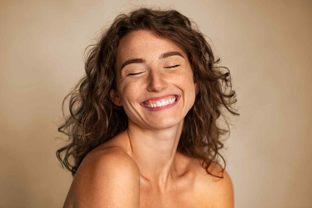 donna sorridente con occhi chiusi concetto di benessere