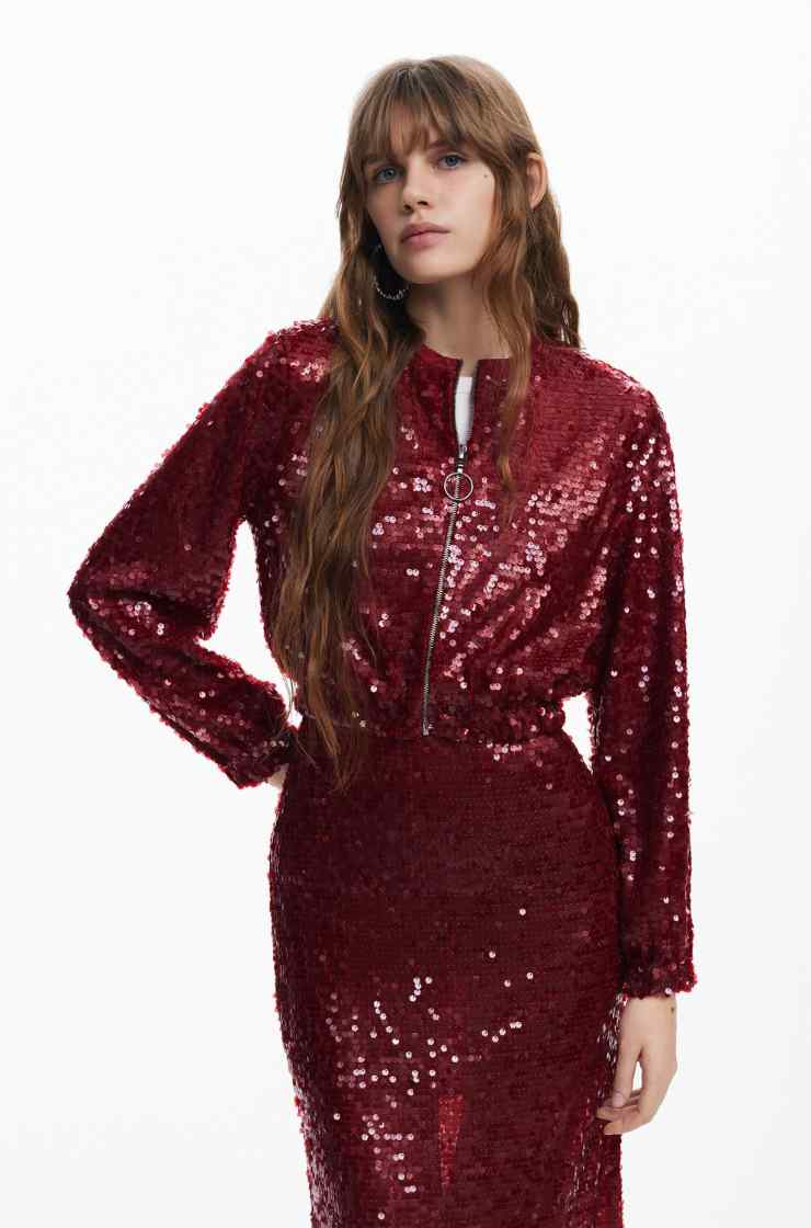 modella con giubbino e gonna rossa in paillettes