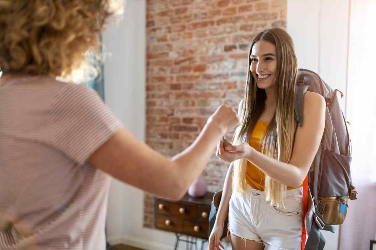 giovane ragazza prende le chiavi della stanza in affitto