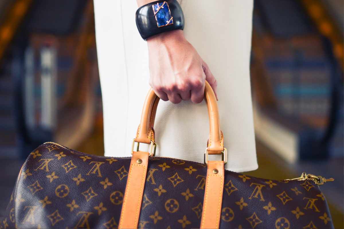 Come riconoscere una borsa contraffatta, donna con in mano una Louis Vuitton