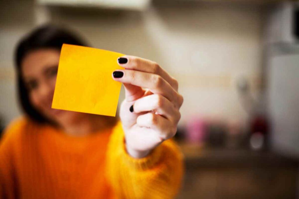 Donna con un post it in mano mostra le cose da fare con l'inizio dell'anno nuovo