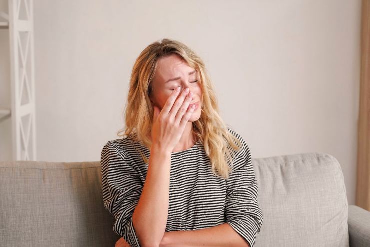 ragazza che piange seduta sul divano