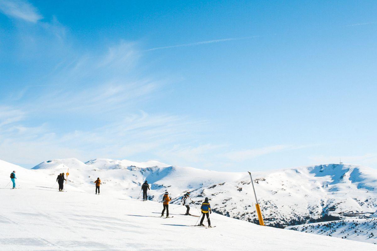 paesaggio con neve e persone che sciano