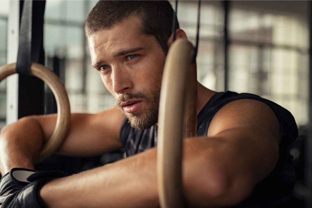 Uomo in palestra che ragiona su cosa fare