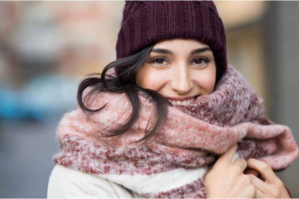 Primo piano di giovane donna con cappello e sciarpa