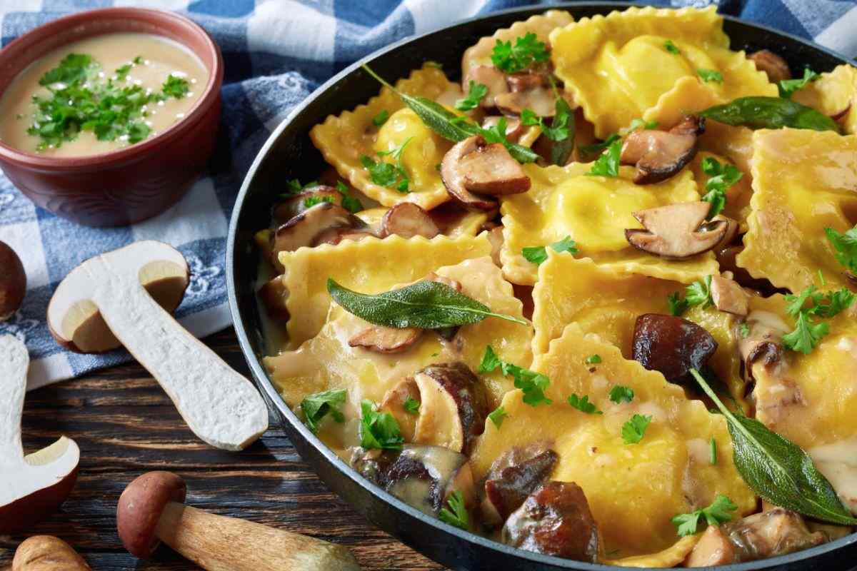 padella con ravioli cotti e conditi con funghi