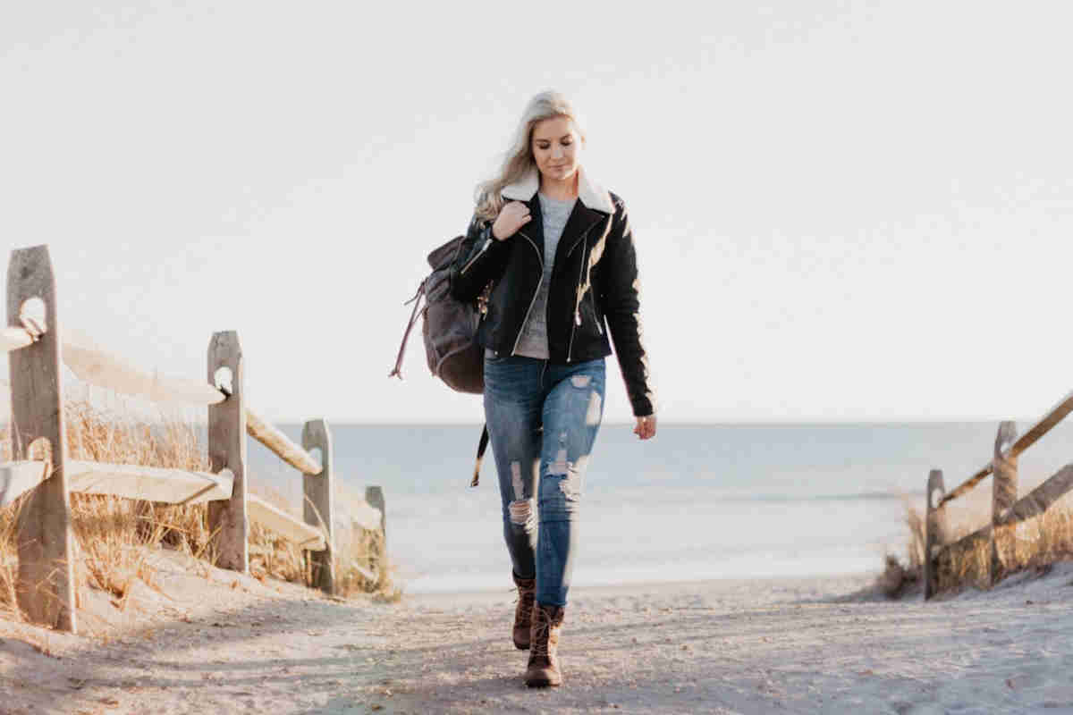 Ragazza con i jeans che cammina, dietro il mare