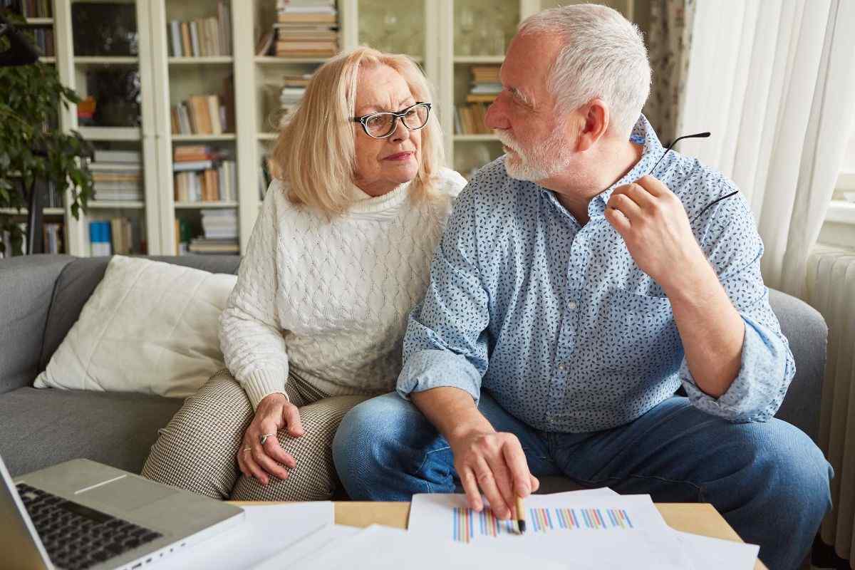 Due persone sedute sul divano con dei fogli sul tavolino