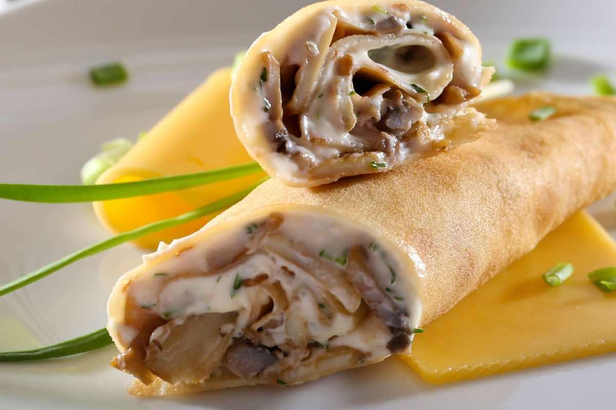 due crepes ripiene e arrotolate su un piatto