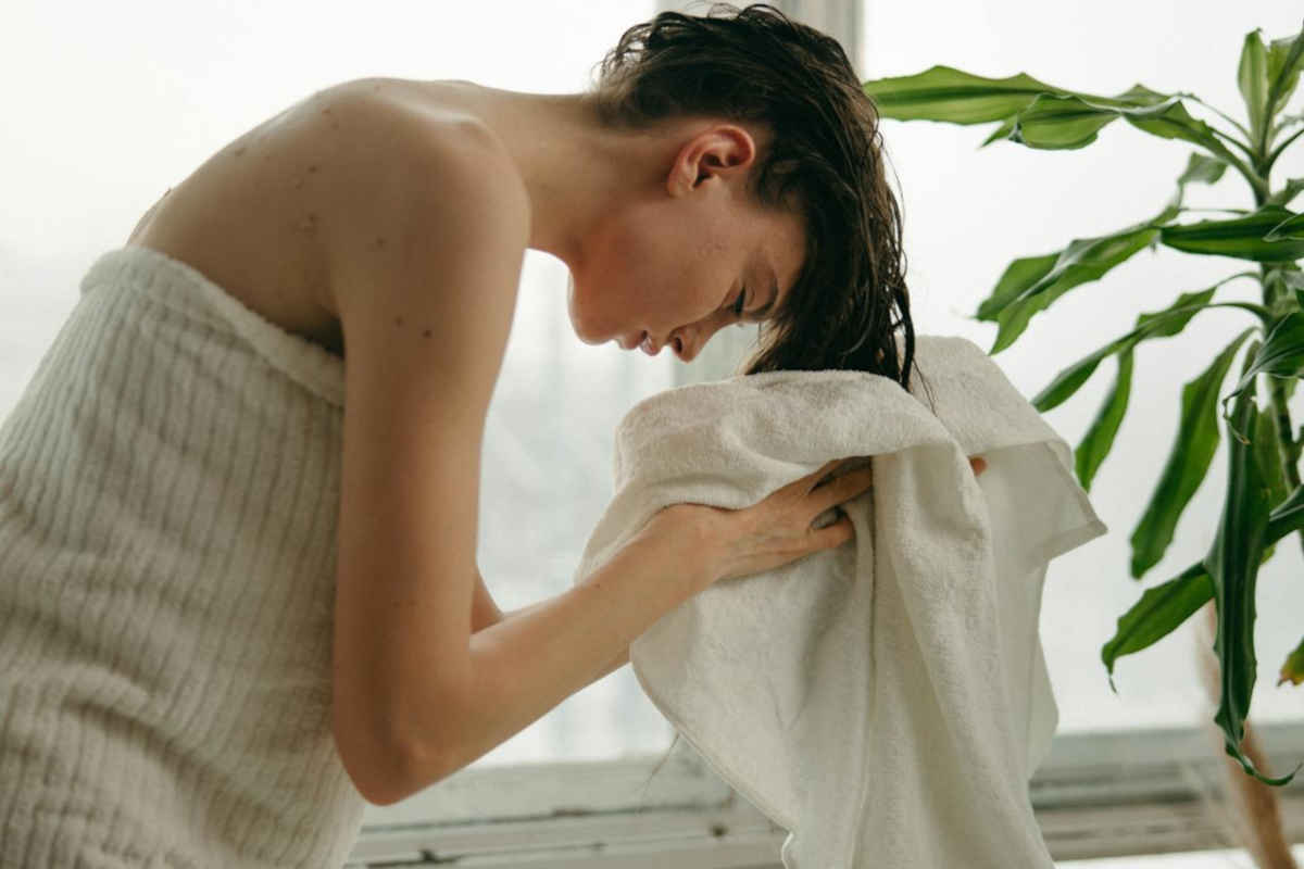 Ragazza che tampona i capelli con asciugamano