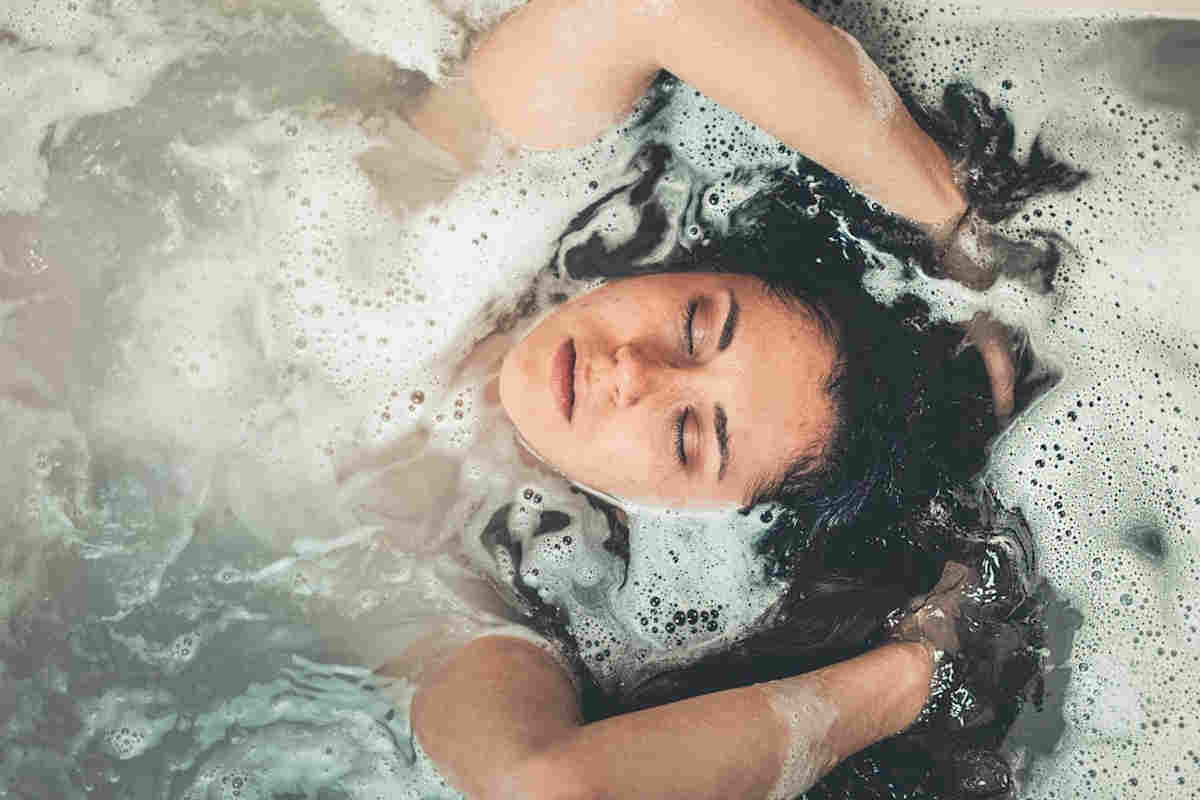 Ragazza immersa nell'acqua della vasca da bagno