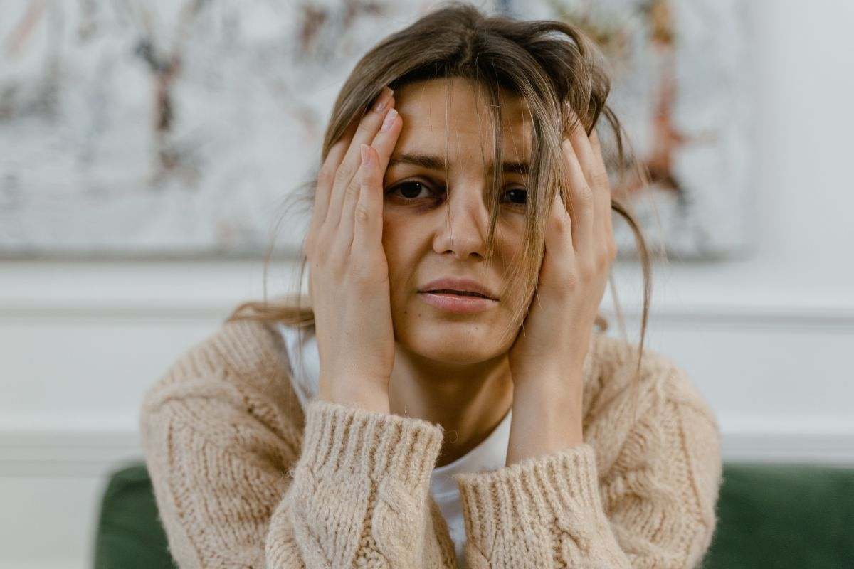 ragazza seduta con le mani tra i capelli